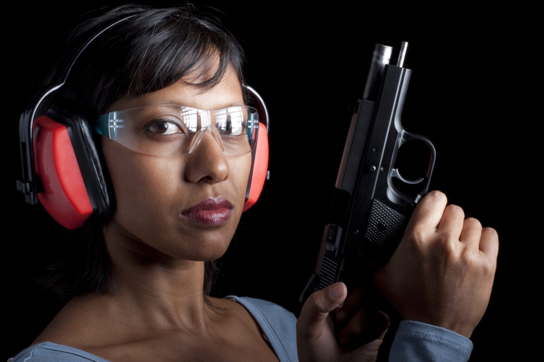 Woman wearing eye and ear protection at a gun range